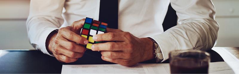 business person playing rubik's cube